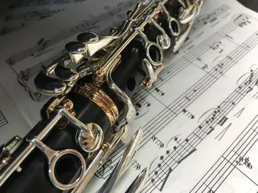 A clarinet resting across printed sheet music